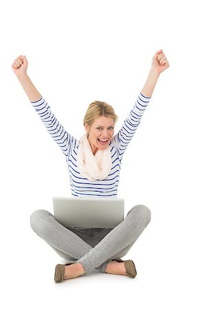 Pretty blonde cheering at camera with laptop sitting on floor on white background Stock Photo - Budget Royalty-Free & Subscription, Code: 400-07467153