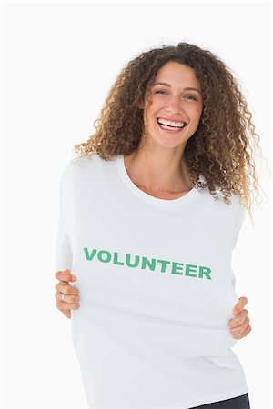 Happy volunteer showing her tshirt to camera on white background Stockbilder - Microstock & Abonnement, Bildnummer: 400-07467201