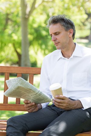 Businessman with disposable cup reading newspaper in the park Stock Photo - Budget Royalty-Free & Subscription, Code: 400-07467406