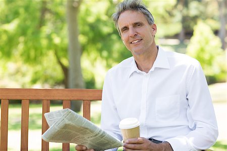 Portrait of confident businessman with disposable cup and newspaper in the park Stock Photo - Budget Royalty-Free & Subscription, Code: 400-07467408