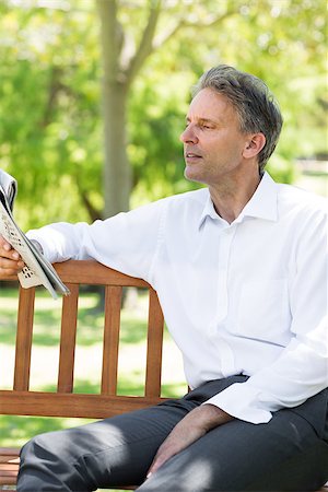 Businessman reading newspaper on bench at the park Stock Photo - Budget Royalty-Free & Subscription, Code: 400-07467403