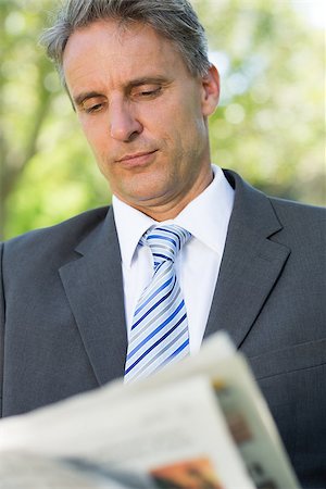 Mature businessman reading newspaper at park Stock Photo - Budget Royalty-Free & Subscription, Code: 400-07467420