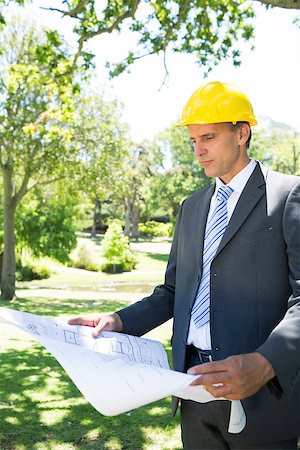 Well dressed businessman reading blueprint in park Stock Photo - Budget Royalty-Free & Subscription, Code: 400-07467479