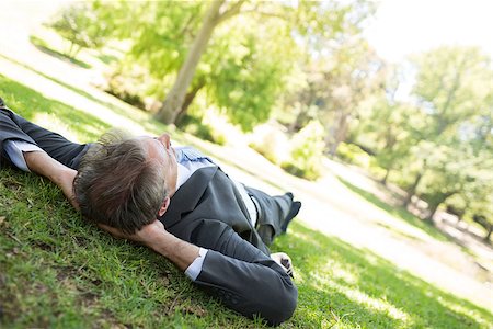Businessman with hands behind head lying on grass in park Stock Photo - Budget Royalty-Free & Subscription, Code: 400-07467485