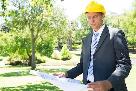 Well dressed businessman studying blueprint in park Stock Photo - Budget Royalty-Free & Subscription, Code: 400-07467480