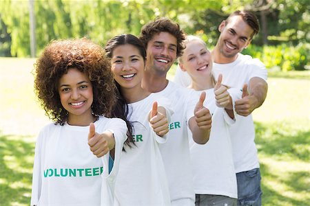 simsearch:400-07273325,k - Portrait of confident young volunteers gesturing thumbs up at park Foto de stock - Royalty-Free Super Valor e Assinatura, Número: 400-07467632