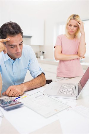 Worried couple with bills and laptop in the kitchen at home Stock Photo - Budget Royalty-Free & Subscription, Code: 400-07467773