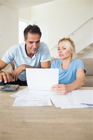 Concentrated couple with bills and calculator in the living room at home Stock Photo - Budget Royalty-Free & Subscription, Code: 400-07467914