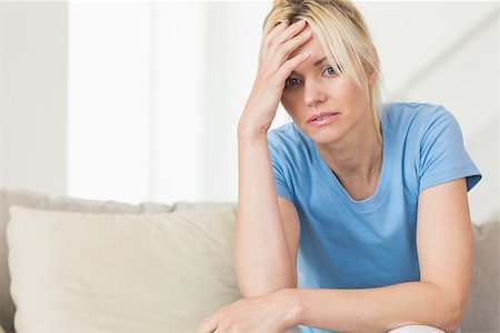 sad woman sitting alone on couch - Worried young woman sitting in the living room at home Stock Photo - Budget Royalty-Free & Subscription, Code: 400-07467918