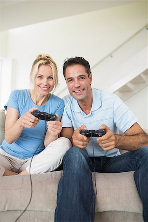 Portrait of a cheerful couple playing video games in the living room at home Stock Photo - Budget Royalty-Free & Subscription, Code: 400-07467928