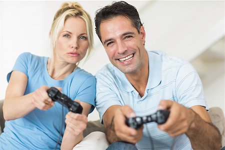 Portrait of a cheerful couple playing video games in the living room at home Photographie de stock - Aubaine LD & Abonnement, Code: 400-07467929