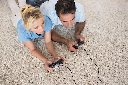 High angle view of a couple playing video games on area rug at home Stock Photo - Budget Royalty-Free & Subscription, Code: 400-07467930