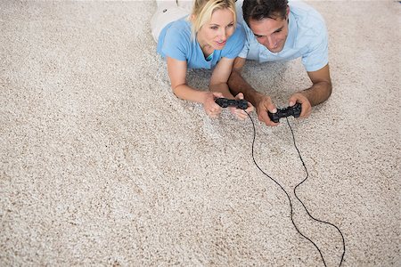 High angle view of a couple playing video games on area rug at home Photographie de stock - Aubaine LD & Abonnement, Code: 400-07467931