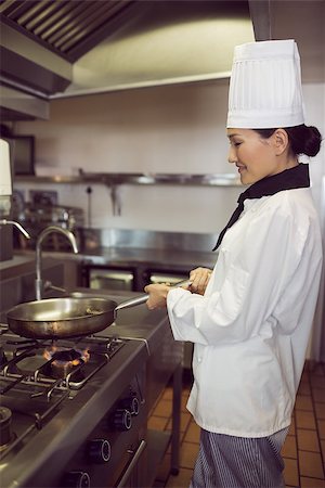 simsearch:695-05770913,k - Side view of a female cook preparing food in the kitchen Stock Photo - Budget Royalty-Free & Subscription, Code: 400-07468025