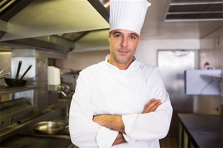 simsearch:400-07468062,k - Portrait of a smiling male cook with arms crossed standing in the kitchen Stockbilder - Microstock & Abonnement, Bildnummer: 400-07468048
