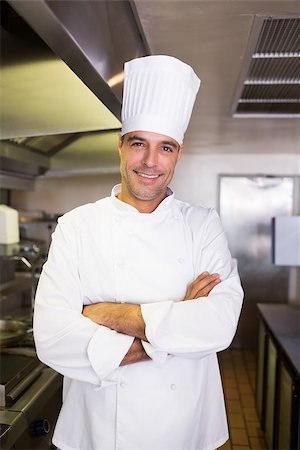 simsearch:400-07468062,k - Portrait of a smiling male cook with arms crossed standing in the kitchen Stockbilder - Microstock & Abonnement, Bildnummer: 400-07468049