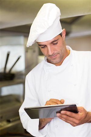 Concentrated male cook using digital tablet in the kitchen Stock Photo - Budget Royalty-Free & Subscription, Code: 400-07468054