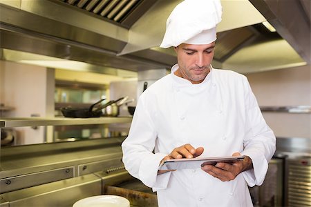 simsearch:400-07468062,k - Concentrated male cook using digital tablet in the kitchen Stockbilder - Microstock & Abonnement, Bildnummer: 400-07468052