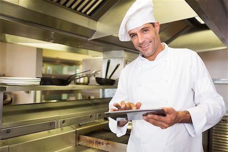 simsearch:400-07468062,k - Portrait of a smiling male cook using digital tablet in the kitchen Stockbilder - Microstock & Abonnement, Bildnummer: 400-07468053