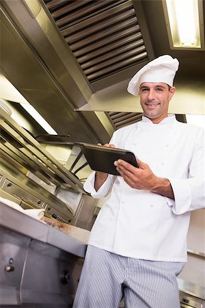 simsearch:400-07468062,k - Portrait of a smiling male cook using digital tablet in the kitchen Stockbilder - Microstock & Abonnement, Bildnummer: 400-07468061