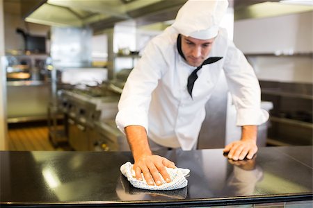 simsearch:400-07468062,k - Male cook wiping the counter top in the kitchen Stockbilder - Microstock & Abonnement, Bildnummer: 400-07468084