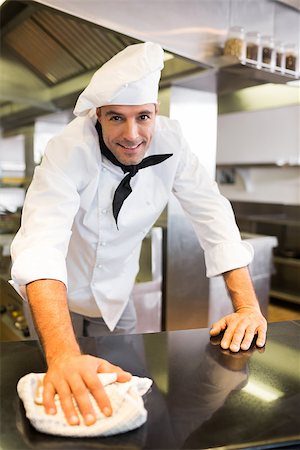 simsearch:400-07468062,k - Portrait of a smiling male cook wiping the counter top in the kitchen Stockbilder - Microstock & Abonnement, Bildnummer: 400-07468087