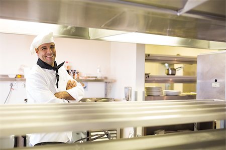 simsearch:400-07468062,k - Portrait of a smiling male cook with arms crossed standing in the kitchen Stockbilder - Microstock & Abonnement, Bildnummer: 400-07468089