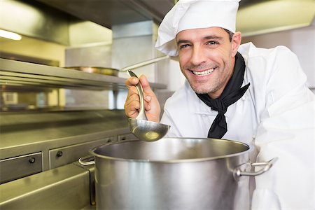 simsearch:400-07468062,k - Portrait of a smiling young male cook tasting food in the kitchen Stockbilder - Microstock & Abonnement, Bildnummer: 400-07468094