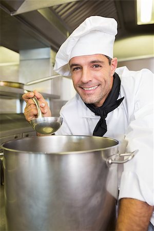 simsearch:400-07468062,k - Portrait of a smiling young male cook tasting food in the kitchen Stockbilder - Microstock & Abonnement, Bildnummer: 400-07468093