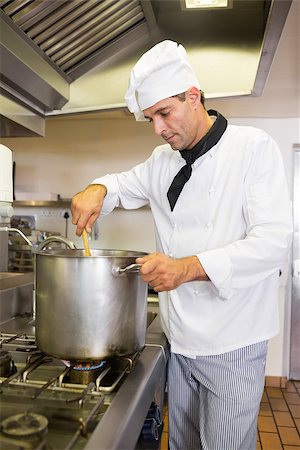 simsearch:630-06724041,k - Side view of a concentrated male chef preparing food in the kitchen Foto de stock - Super Valor sin royalties y Suscripción, Código: 400-07468104
