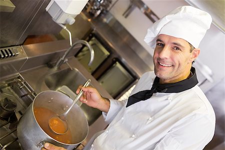 simsearch:400-07468062,k - Portrait of a smiling male chef preparing food in the kitchen Stockbilder - Microstock & Abonnement, Bildnummer: 400-07468114