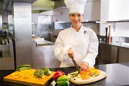 simsearch:400-06105151,k - Portrait of a smiling young female chef cutting vegetables in the kitchen Foto de stock - Super Valor sin royalties y Suscripción, Código: 400-07468153