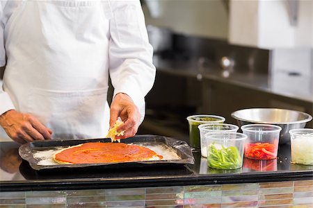 Closeup mid section of a male chef preparing pizza in kitchen Stock Photo - Budget Royalty-Free & Subscription, Code: 400-07468197