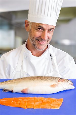 Portrait of a smiling male chef holding tray of raw fish in the kitchen Stock Photo - Budget Royalty-Free & Subscription, Code: 400-07468191