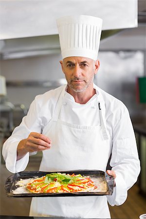 simsearch:400-09222970,k - Portrait of a confident male chef holding cooked food in the kitchen Stock Photo - Budget Royalty-Free & Subscription, Code: 400-07468206