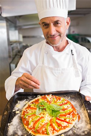 simsearch:400-09222970,k - Portrait of a confident male chef holding cooked food in the kitchen Stock Photo - Budget Royalty-Free & Subscription, Code: 400-07468208