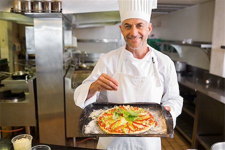 simsearch:400-09222970,k - Portrait of a confident male chef holding cooked food in the kitchen Stock Photo - Budget Royalty-Free & Subscription, Code: 400-07468210