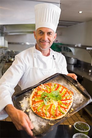 simsearch:400-09222970,k - Portrait of a confident male chef holding cooked food in the kitchen Stock Photo - Budget Royalty-Free & Subscription, Code: 400-07468211