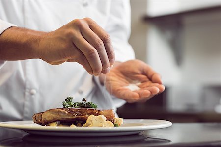 Closeup mid section of a chef putting salt in the kitchen Stock Photo - Budget Royalty-Free & Subscription, Code: 400-07468259