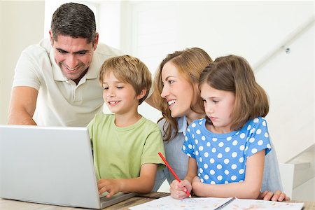 Family using laptop together at table Stock Photo - Budget Royalty-Free & Subscription, Code: 400-07468329