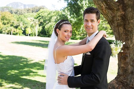 simsearch:400-07473236,k - Portrait of smiling young bride and groom embracing in garden Stockbilder - Microstock & Abonnement, Bildnummer: 400-07468524