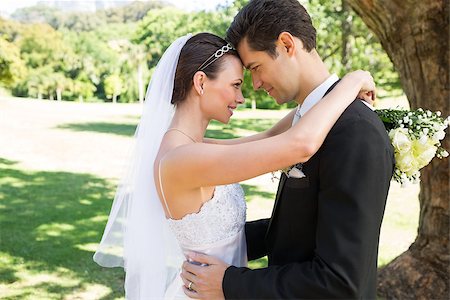 simsearch:400-07473236,k - Side view of newly wed couple with head to head standing in garden Stockbilder - Microstock & Abonnement, Bildnummer: 400-07468525