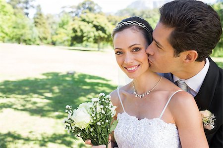 simsearch:400-07473234,k - Young groom kissing beautiful bride on cheek in garden Stock Photo - Budget Royalty-Free & Subscription, Code: 400-07468522