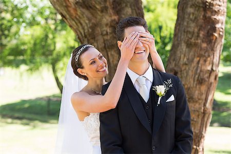 simsearch:400-07473236,k - Happy young bride covering eyes of groom in garden Stockbilder - Microstock & Abonnement, Bildnummer: 400-07468559