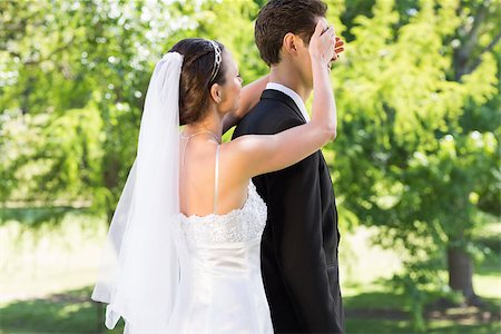 simsearch:400-07473234,k - Side view of young bride covering eyes of groom in garden Stock Photo - Budget Royalty-Free & Subscription, Code: 400-07468569