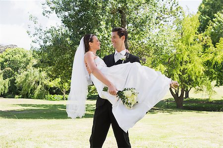 Young groom carrying bride in arms at garden Stock Photo - Budget Royalty-Free & Subscription, Code: 400-07468585