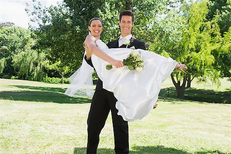 simsearch:400-07473236,k - Portrait of happy young groom lifting bride in arms at garden Stockbilder - Microstock & Abonnement, Bildnummer: 400-07468588