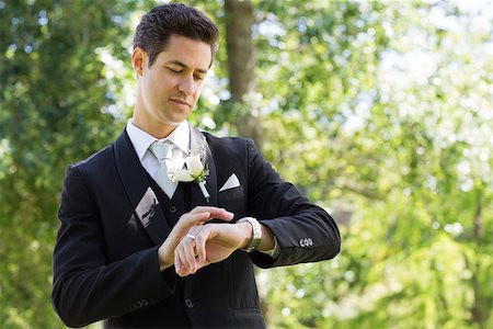 Young smart groom checking time in garden Stock Photo - Budget Royalty-Free & Subscription, Code: 400-07468589