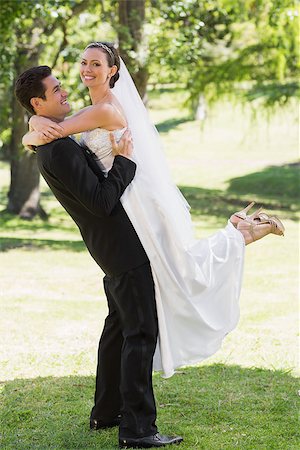 simsearch:400-07473236,k - Full length side view of young groom lifting bride in garden Stockbilder - Microstock & Abonnement, Bildnummer: 400-07468582