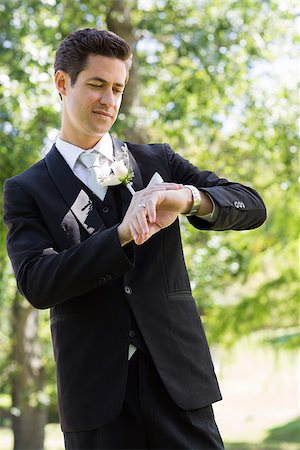 Young smart bridegroom checking time in garden Stock Photo - Budget Royalty-Free & Subscription, Code: 400-07468590